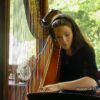 Woman playing harp in sunlit room