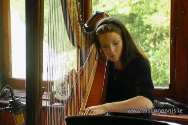 Woman playing harp in sunlit room