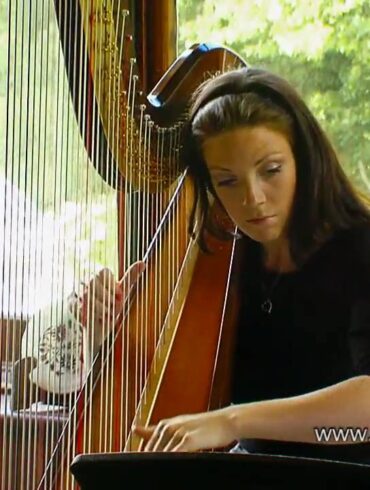 Woman playing harp in sunlit room