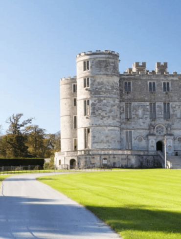 Historic gray stone castle under clear blue sky.