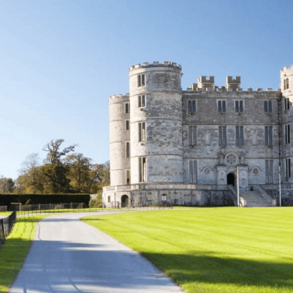 Historic gray stone castle under clear blue sky.