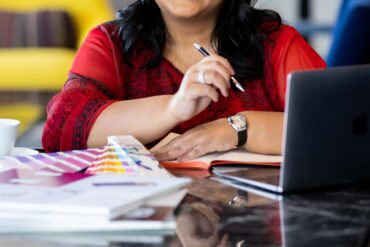Smiling woman with laptop and colour swatches.
