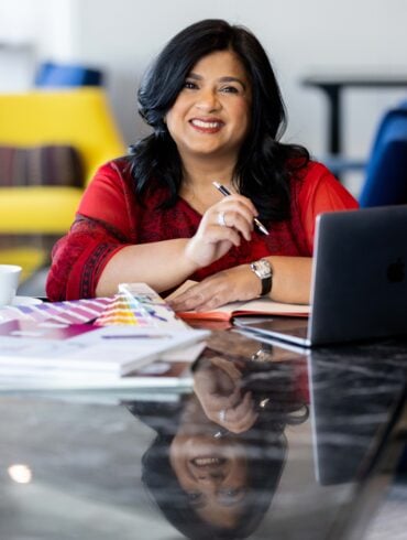 Smiling woman with laptop and colour swatches.