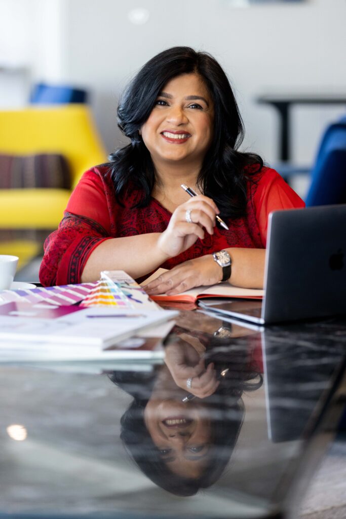 Smiling woman with laptop and colour swatches.
