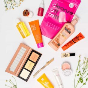 Assorted skincare products on white background with flowers.