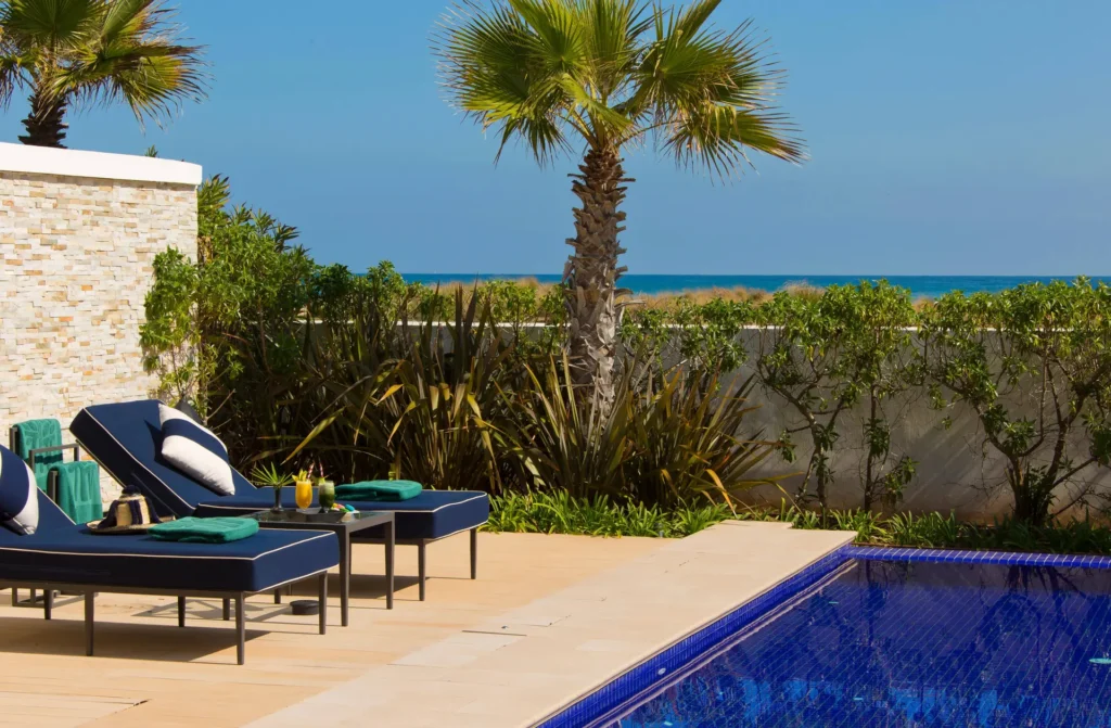 Banyan Tree Tamouda Bay Poolside sun loungers facing the ocean.