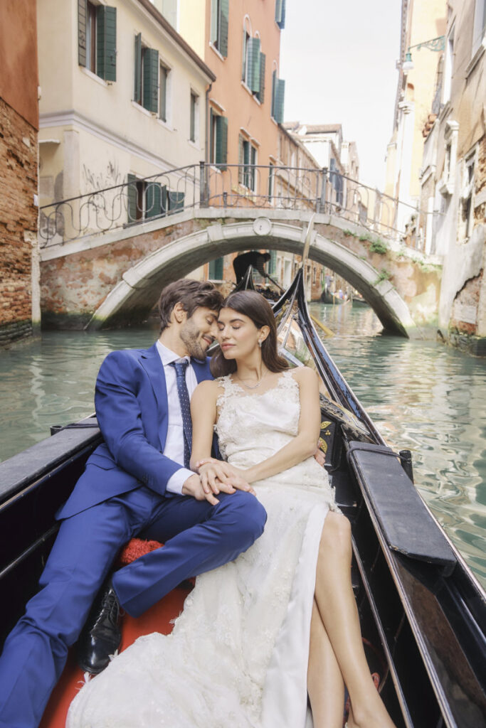A Vision Of Venice Weddings Couple in gondola under Venice bridge.