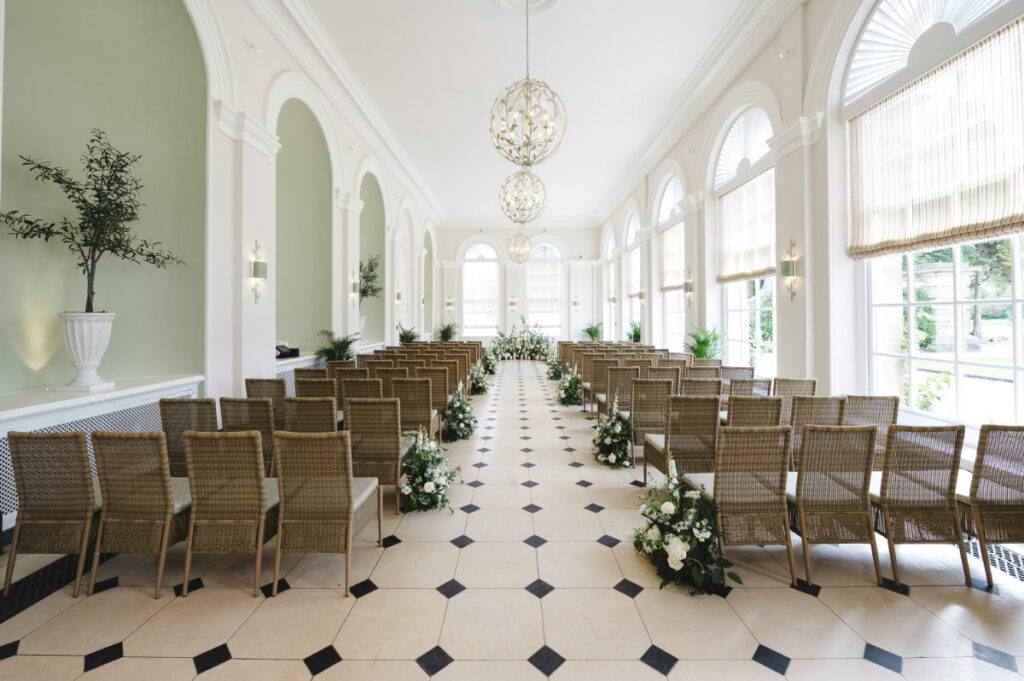 Bespoke Blenheim Wedding Ceremonies & Receptions Elegant wedding ceremony hall with floral decorations.