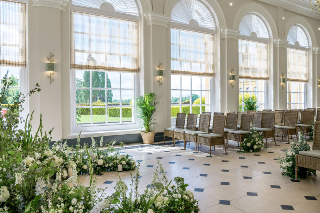 Bespoke Blenheim Wedding Ceremonies & Receptions Bright wedding ceremony room with floral decorations.