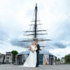 Wedding couple in front of historic ship.