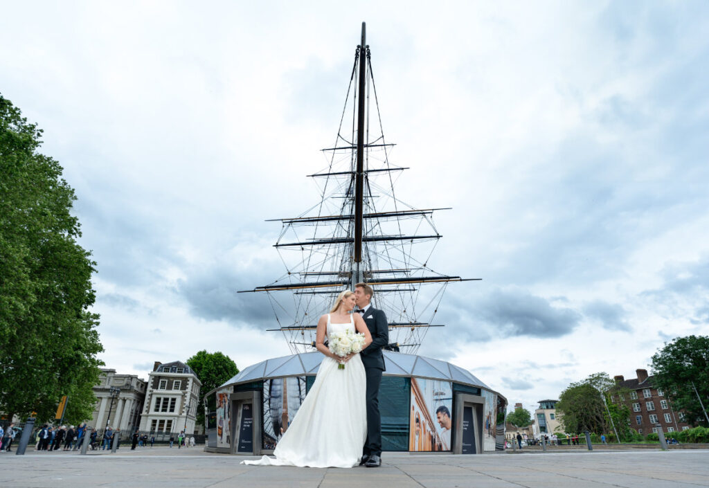A Nautical Dream: A Timeless Wedding Shoot at Cutty Sark, Greenwich Wedding couple in front of historic ship.