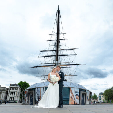 Wedding couple in front of historic ship.