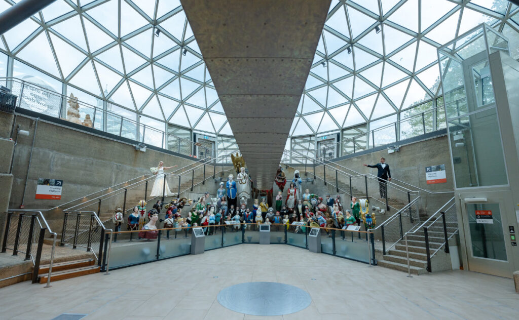 A Nautical Dream: A Timeless Wedding Shoot at Cutty Sark, Greenwich Exhibit hall with numerous ship figureheads.