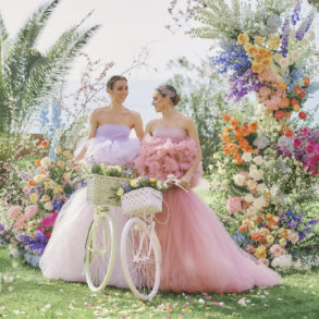 Two women in pastel dresses with floral decorations