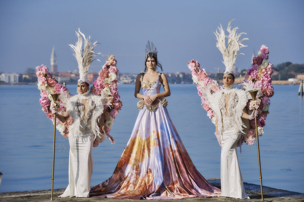 A Vision Of Venice From An International Team Of Creatives People in extravagant costumes by the water