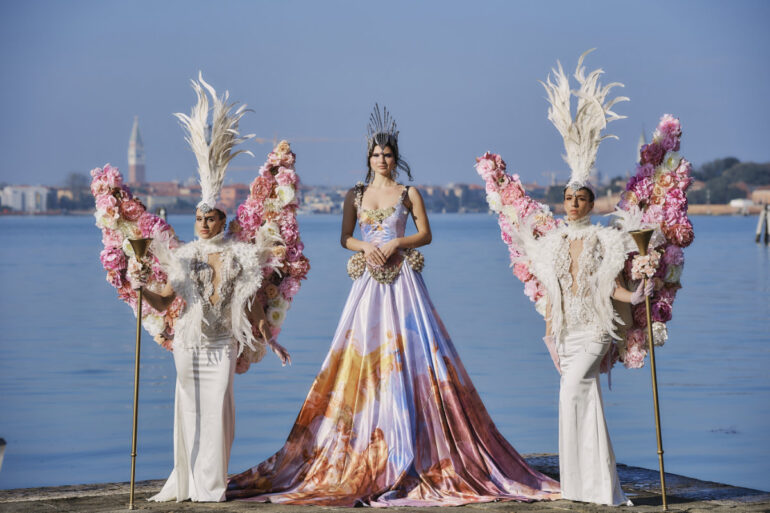 People in extravagant costumes by the water
