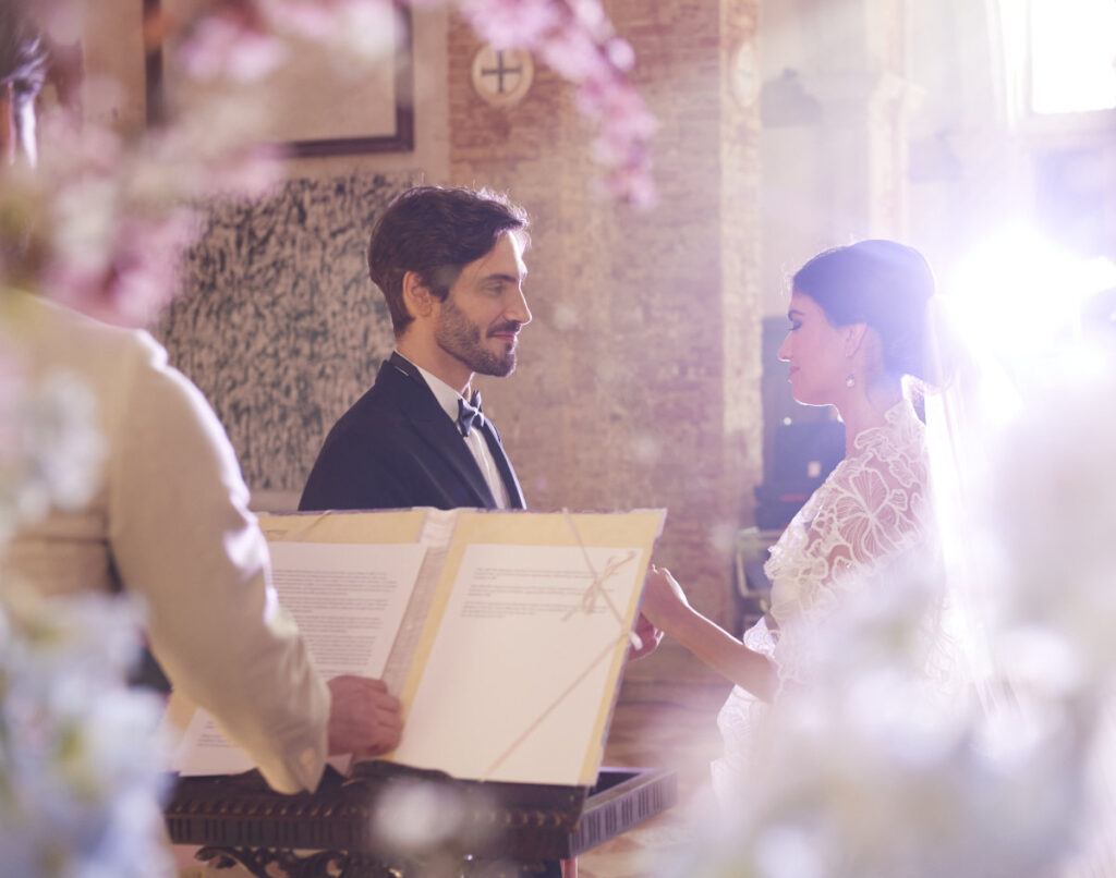 A Vision Of Venice From An International Team Of Creatives Bride and groom exchanging vows in church