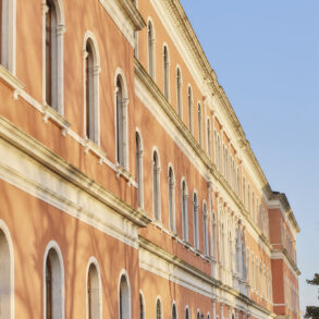 Historic building with arched windows in sunlight.