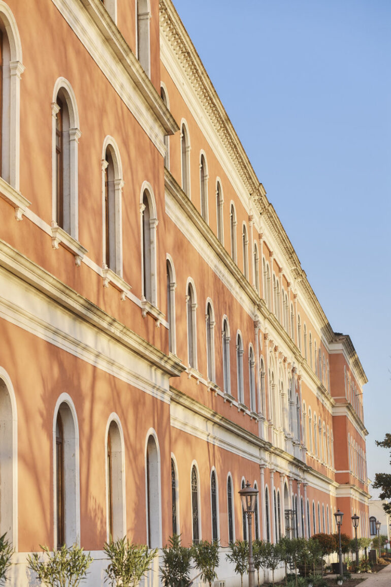 Historic building with arched windows in sunlight.