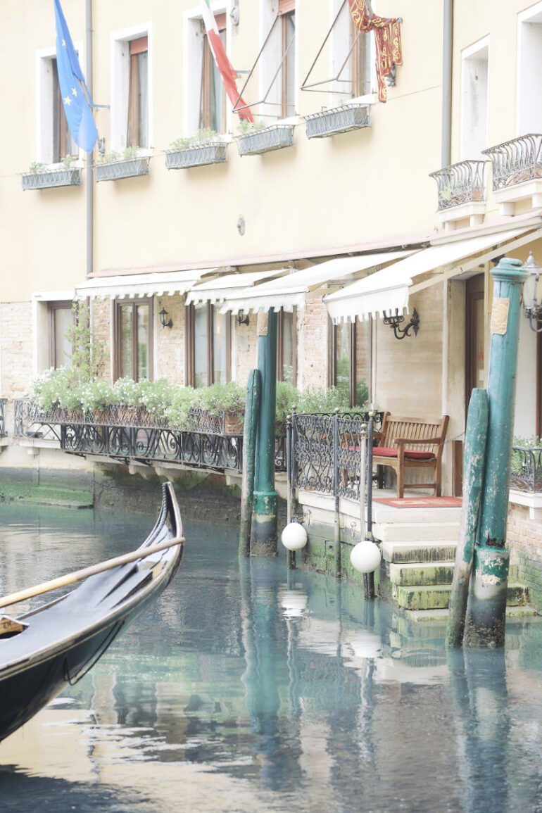 Venetian canal with gondola beside buildings