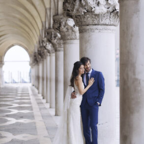 Bride and groom under ornate arches.