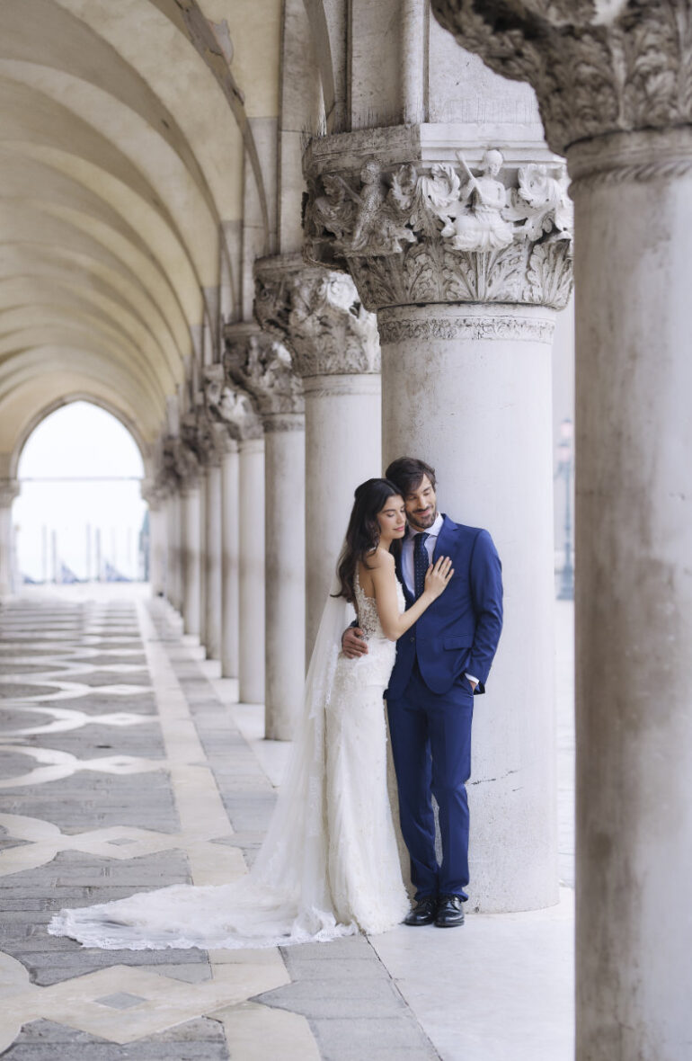Bride and groom under ornate arches.