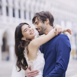 Happy bride and groom hugging outdoors.