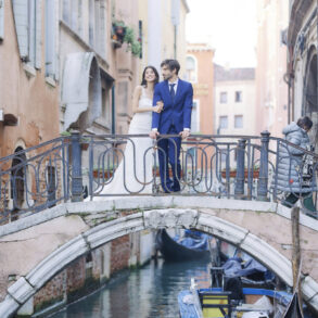 Bride and groom on Venice bridge over canal.