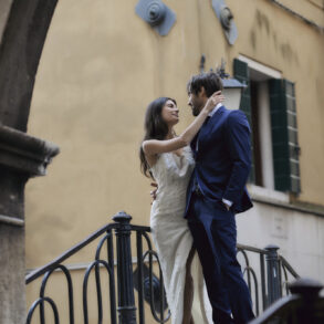 Couple embracing on a staircase in wedding attire.