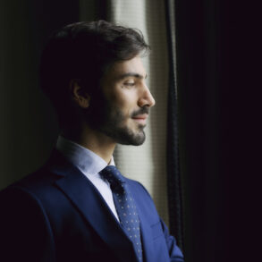 Man in suit looking out window