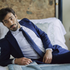 Man in suit lying on bed