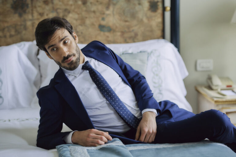 Man in suit lying on bed
