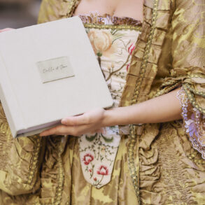 Person holding vintage book in ornate costume