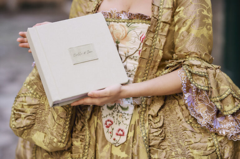 Person holding vintage book in ornate costume