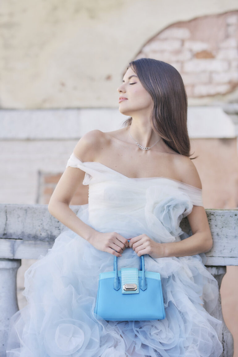 Woman in blue dress with matching handbag