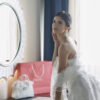Woman in white dress near mirror.