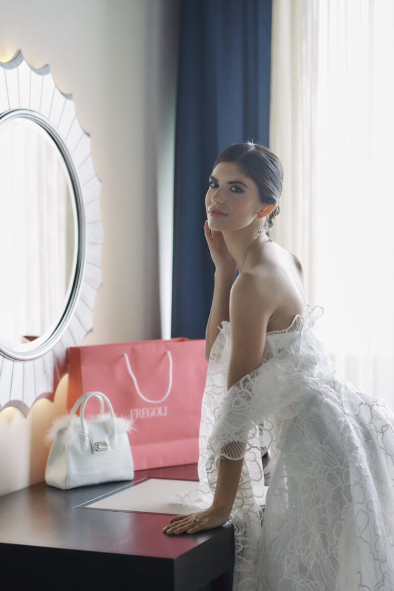 Woman in white dress near mirror.