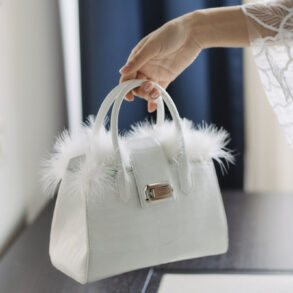 White handbag with feather accents