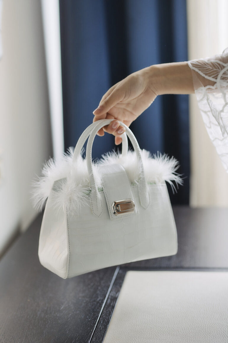 White handbag with feather accents