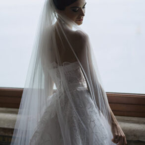 Bride wearing elegant white wedding dress with veil.