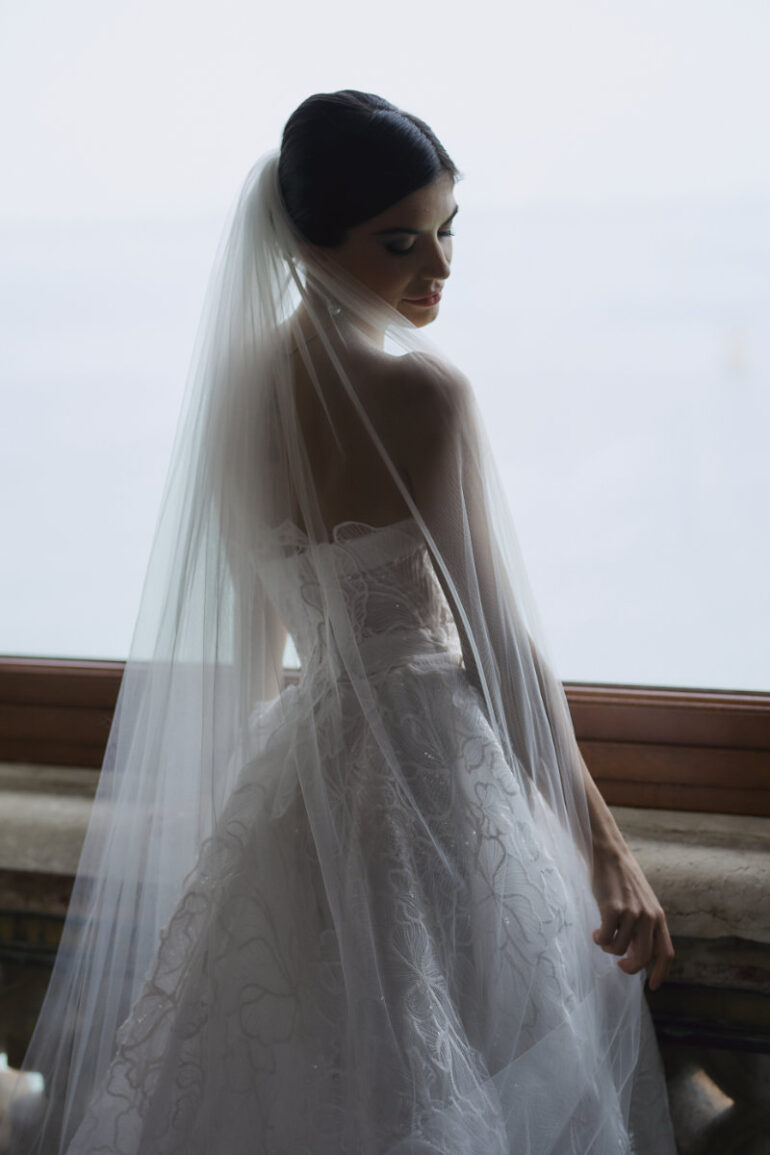 Bride wearing elegant white wedding dress with veil.