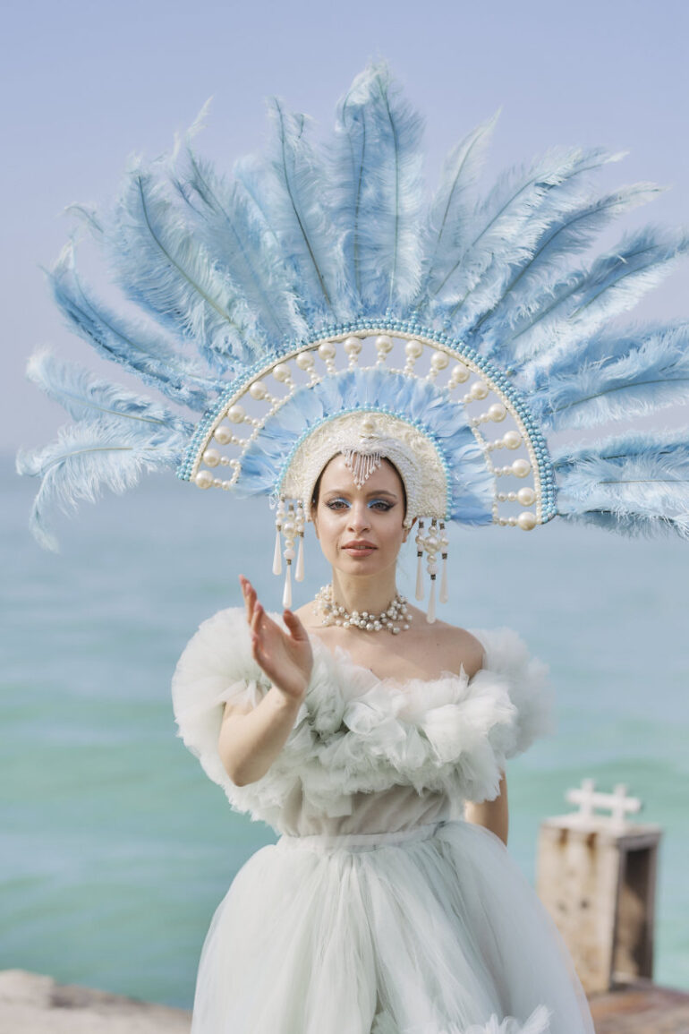 Woman in elaborate costume by the sea