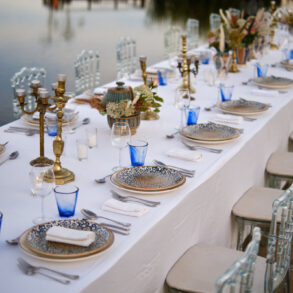 Elegant outdoor dining setup by lakeside.