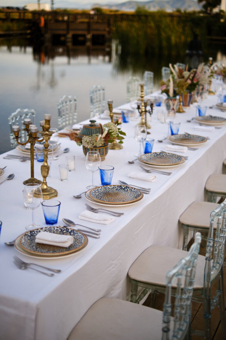 Elegant outdoor dining setup by lakeside.