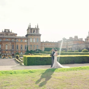 Wedding couple in front of grand estate building.