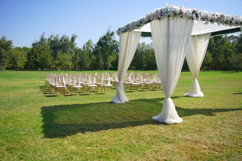 Outdoor wedding setup with chairs and floral canopy