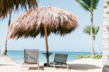 Tropical beach with palm trees and a sunshade.