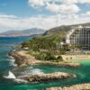 Coastal resort with scenic ocean view, lush mountains.