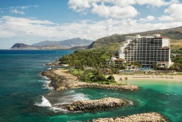 Coastal resort with scenic ocean view, lush mountains.