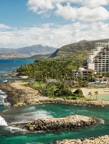 Coastal resort with scenic ocean view, lush mountains.